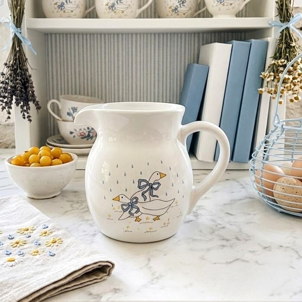 country-style pitcher two geese wearing blue bows in the rain 80s whimsical